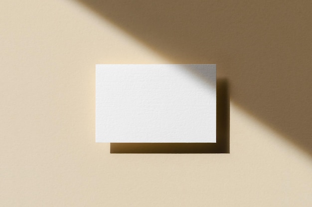 Business card mockup on a beige background with shadow overlay 85x55 mm