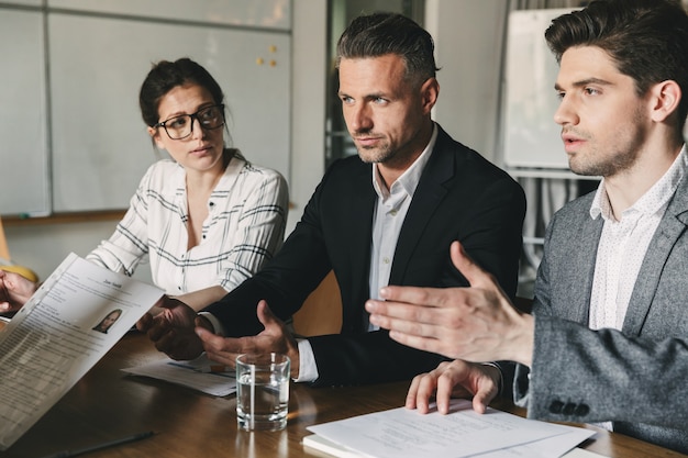 Business, career and placement concept - board of directors sitting at table in office, and examining resume of female worker during corporate meeting