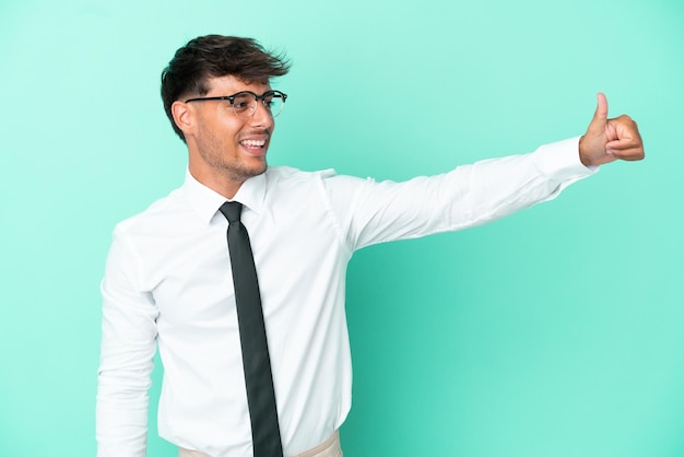 Business caucasian man isolated on blue background giving a thumbs up gesture