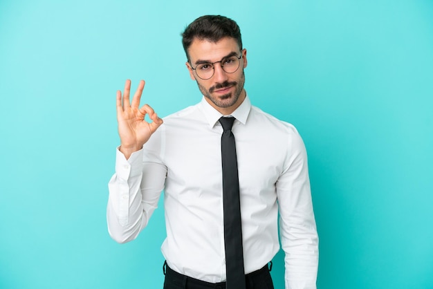 Business caucasian man isolated on blue background showing ok sign with fingers