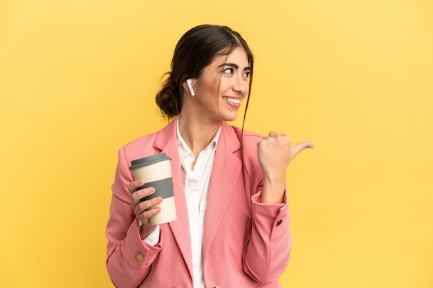 Business caucasian woman isolated on yellow background pointing to the side to present a product