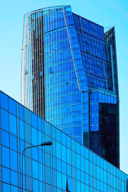 Business center architecture of modern metal and glass skyscraper with reflection of the blue sky