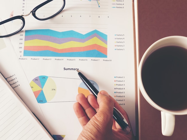 Business chart and notebook on wooden table.