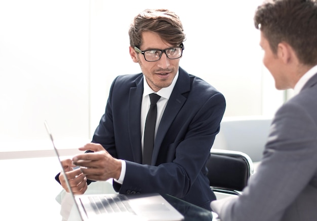 Business colleagues discuss something sitting at their Desk