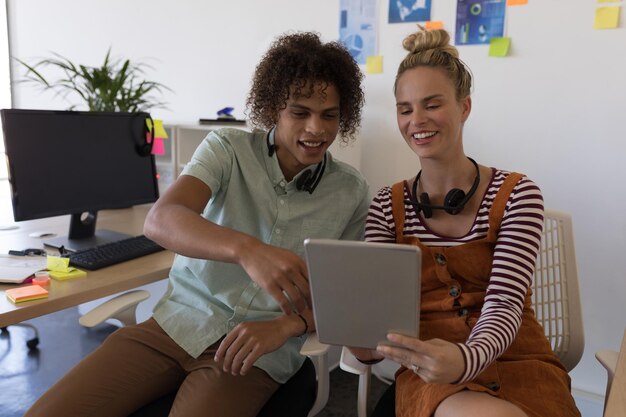 Business colleagues discussing over digital tablet in office