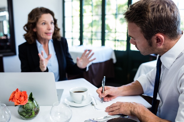 Business colleagues discussing and taking notes while having a meeting