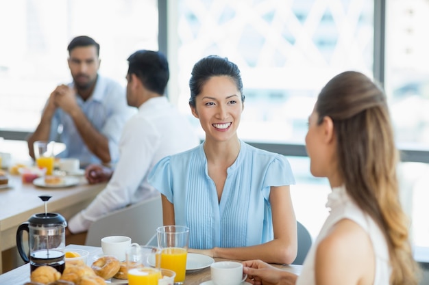 Business colleagues having breakfast together in office cafeteria