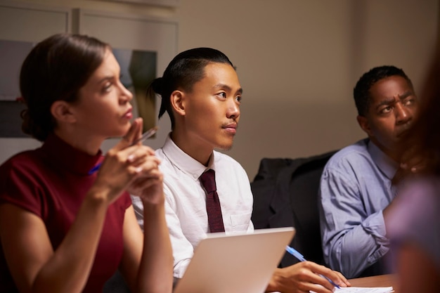 Business colleagues listening at evening meeting close up