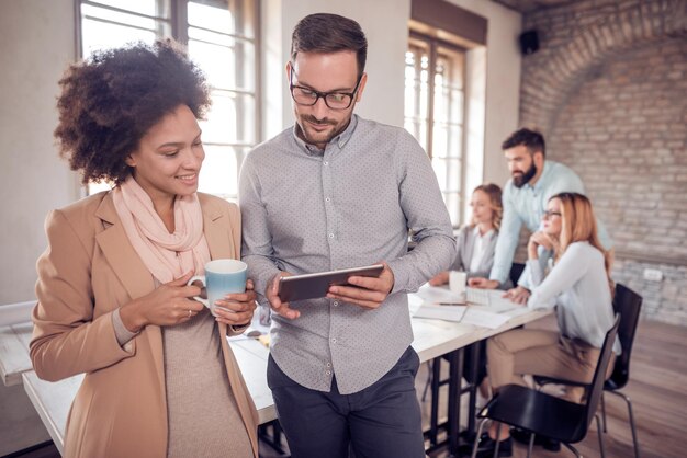 Business colleagues in modern office using tablet