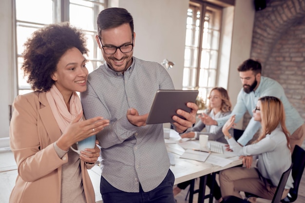 Business colleagues in modern office using tablet