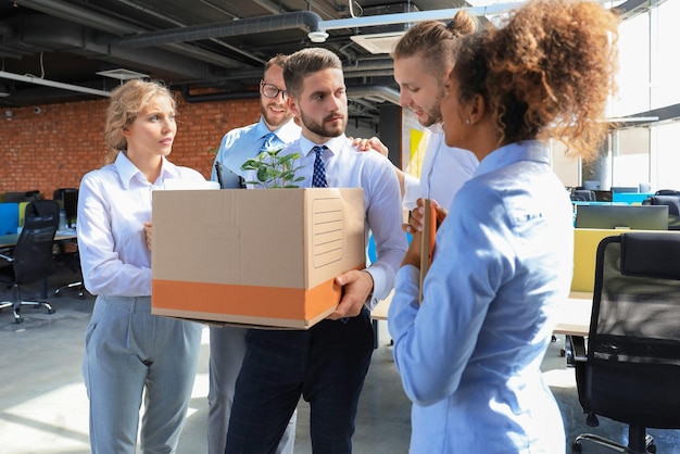 Business colleagues say goodbye to the dismissed employee