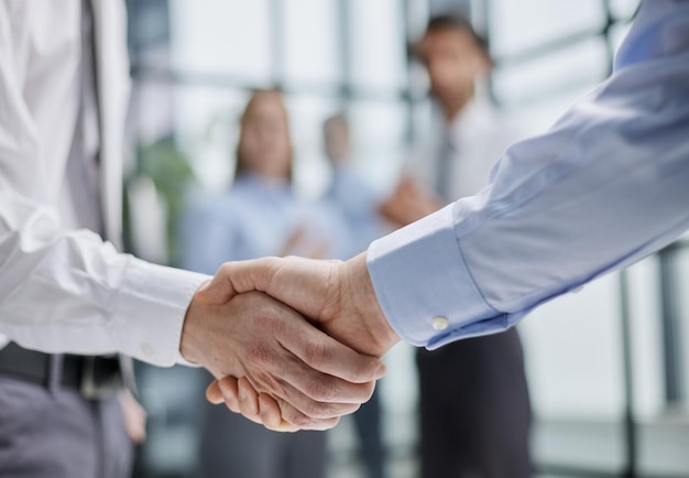 Business colleagues shaking hands in an office hallway