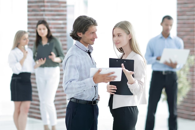 Photo business colleagues talking standing in a modern office