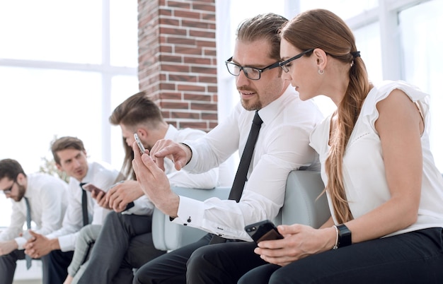 Business colleagues use a smartphone and discussing something