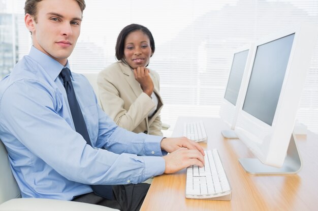 Business colleagues using computers at desk