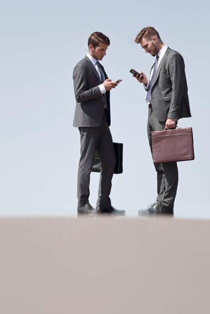 Business colleagues with mobile phones standing on the streetphoto with copy space