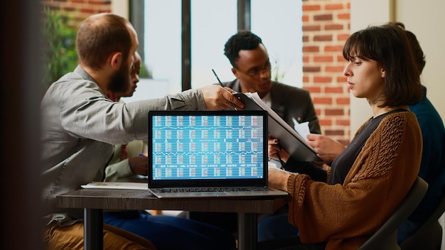 Business colleagues wokring with real time stock market\
exchange statistics on laptop in startup office. using capital\
investment money and profit trade rate, forex index and analysis.\
close up.