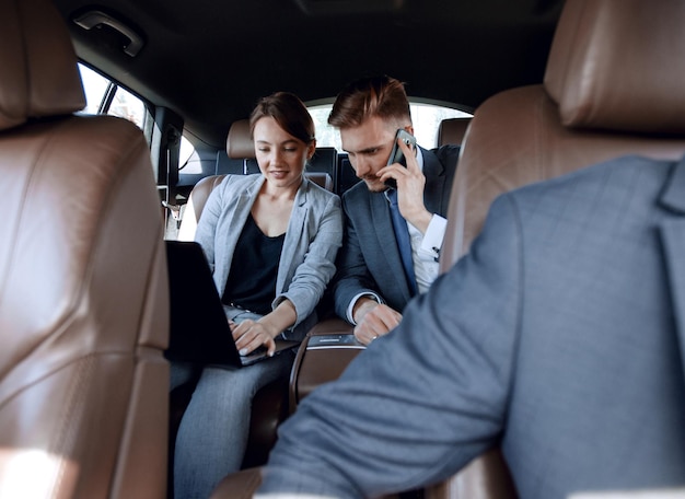 Business colleagues working in the car