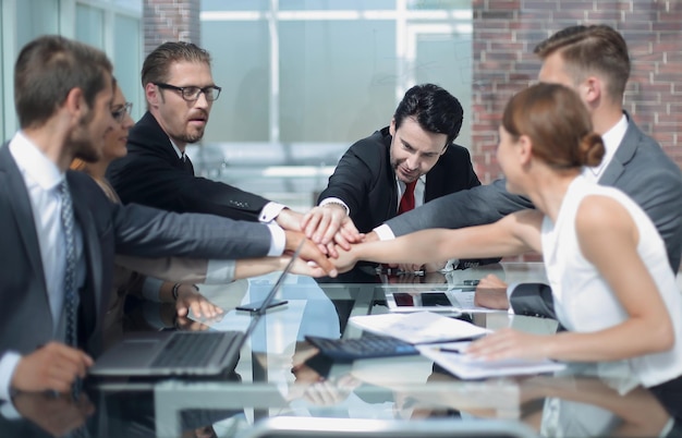 Business colleagues working in the office holding hands together