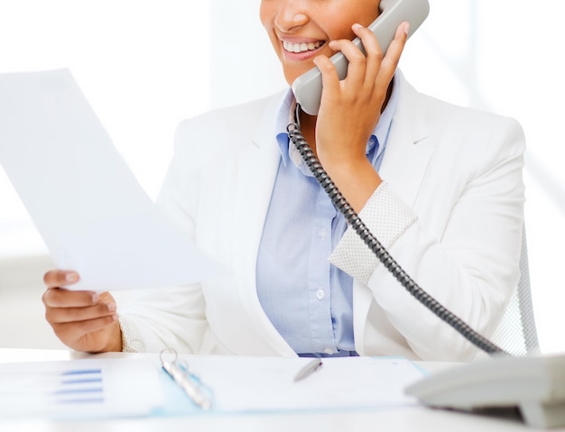 business, and communication concept - smiling african businesswoman with phone in office