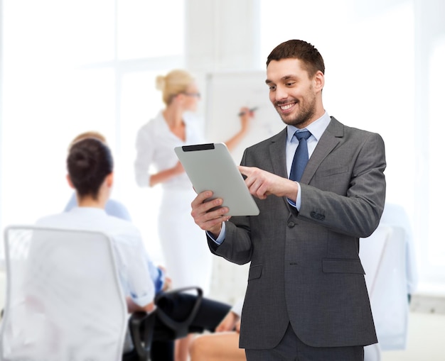 business, communication, modern technology and office concept - smiling buisnessman with tablet pc computer