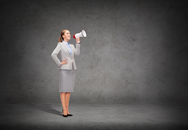 business, communication and office concept - smiling businesswoman with megaphone screaming at someone imaginary