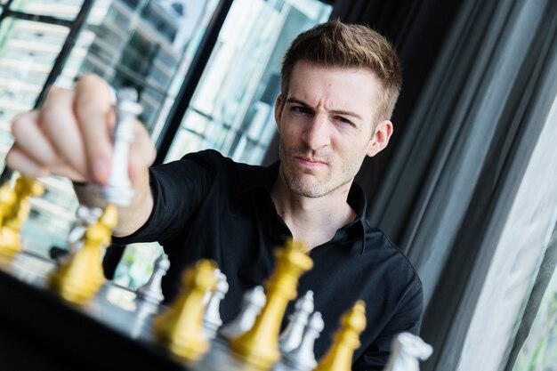 チェスのゲームボードをプレーする男とビジネス競争の概念