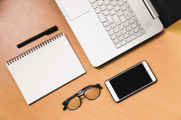 Business Computer notebook lwith smartphone and notebook on the wooden desk