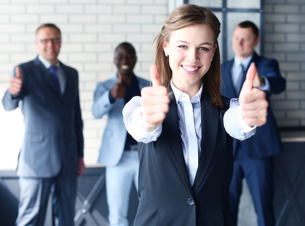 Photo business concept - attractive businesswoman with team in office showing thumbs up