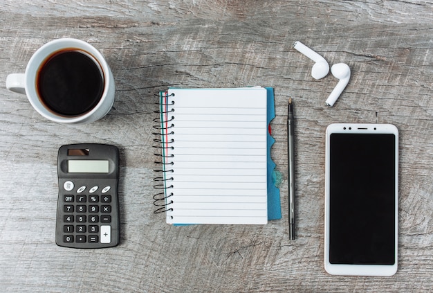 Foto concetto di business, blocco note vuoto, smartphone e caffè, su un tavolo di legno,