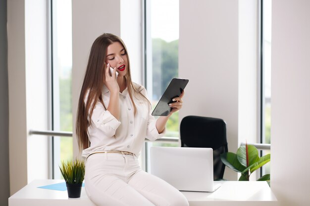 Business concept - brunette businesswoman talking on the phone in the office,