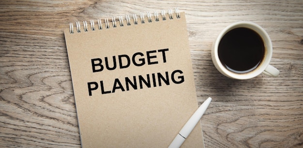 Photo business concept budget planning text on notepad with coffee on table