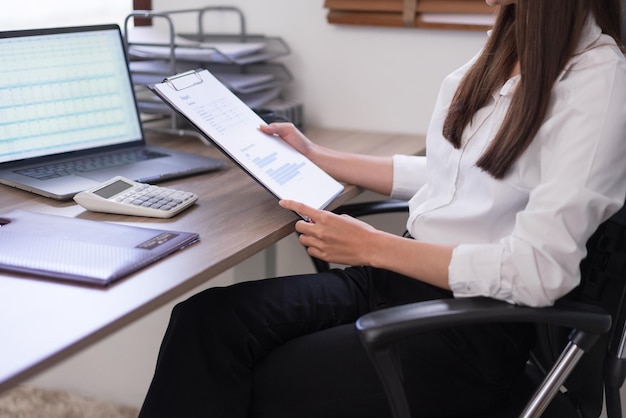 Concetto di business donna d'affari in possesso di appunti e la lettura di documenti aziendali per l'analisi del budget