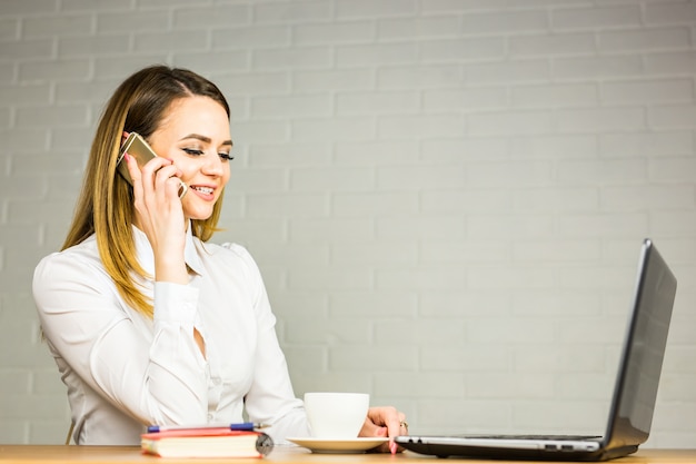 Business concept - businesswoman talking on the phone in office