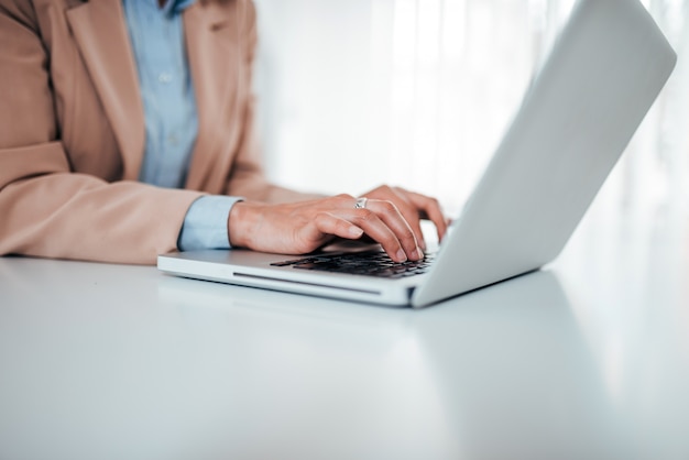 Business concept. Close-up image of woman in formal wear typing on laptop.