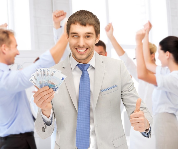 Photo business concept - happy businessman with cash money in office