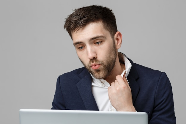 Business Concept - Portret knappe stressvolle zakenman in pak schok kijken naar werk in laptop. Witte achtergrond.