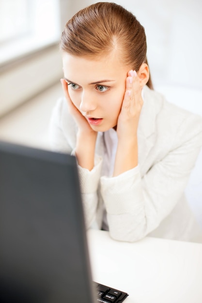 business concept - stressed businesswoman with computer in office