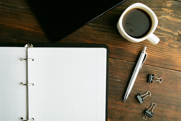 Business concept with notebook, coffee and notepad on brown wooden table