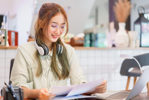 Business concept Woman entrepreneur reads document and working on laptop in coworking space office