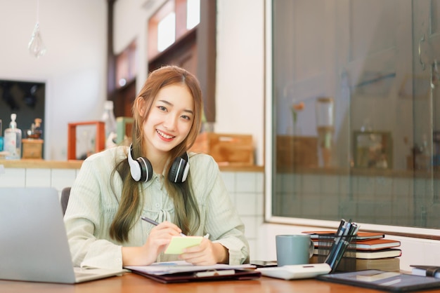 Business concept Woman entrepreneur writing idea in post it notes while working in coworking space