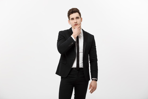 Business concept young handsome man in black suit looking at copyspace smiling thinking or dreaming