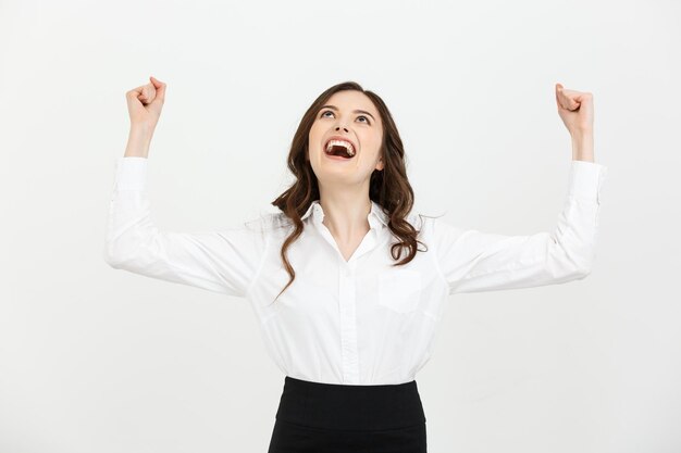 Business concept young happy businesswoman with hands in the air is celebrating success on white bac