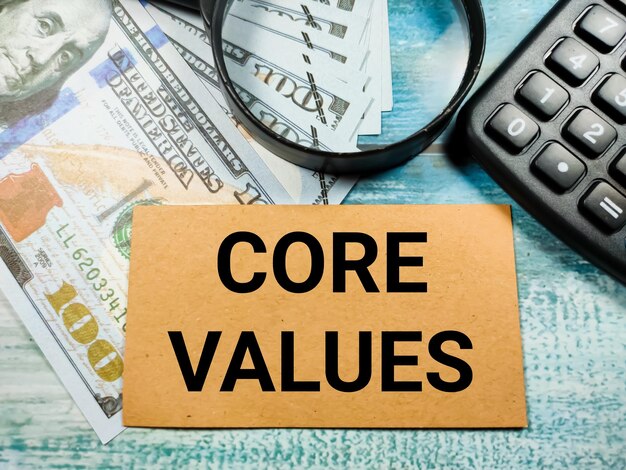 Business conceptText CORE VALUES with banknotemagnifying glass and calculator on wooden background