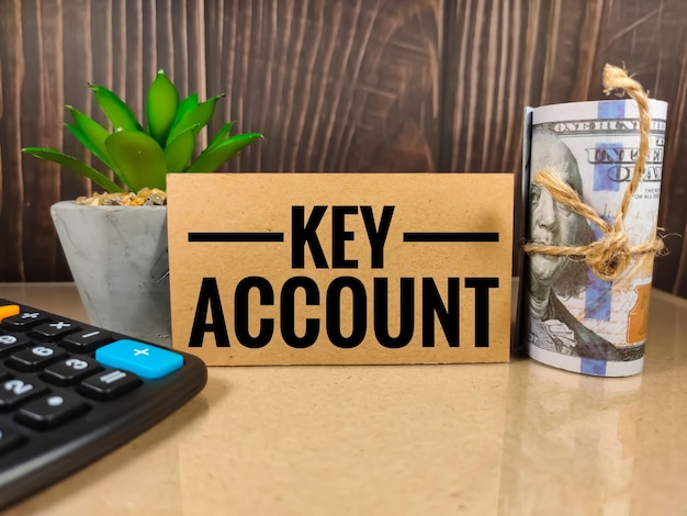 Бизнес-концепцияText KEY ACCOUNT с банкнотой и калькулятором на светлом столе