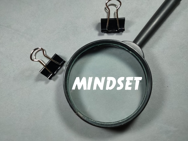 회색 배경에 종이 클립이 있는 비즈니스 개념텍스트 MINDSET 쓰기 돋보기