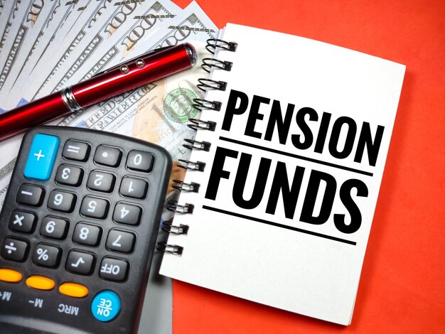 事業コンセプトText PENSION FUNDS with電卓ペンと紙幣グレーと赤の背景