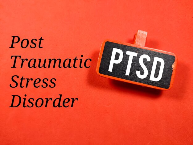 Photo business concepttext ptsd writing on colored wooden board on a red background