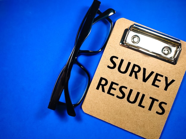 Photo business concepttext survey results with glasses on blue background