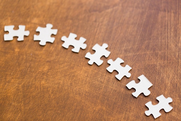 business and connection concept - close up of puzzle pieces on wooden surface